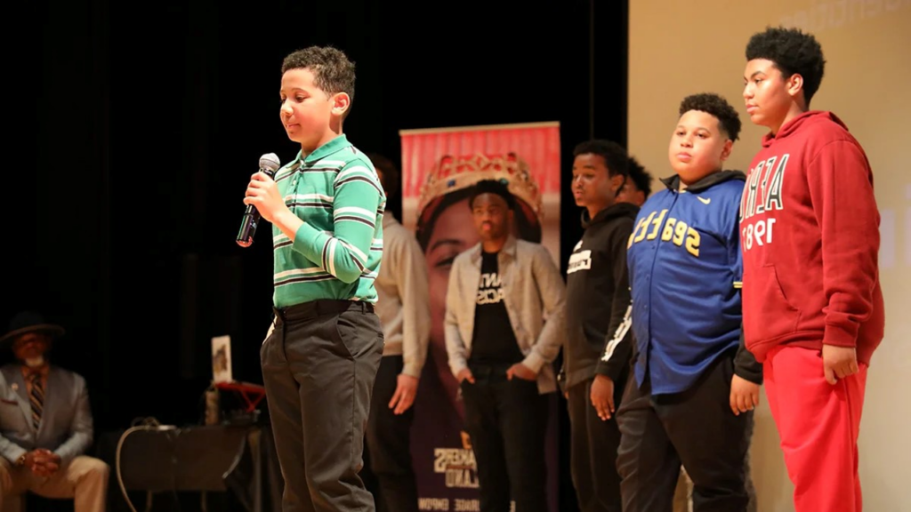 Kingmakers student with microphone preparing to speak to the audience